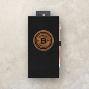 Black Check Presenter with pen loop and credit card pocket. The cover features a circular window with a copper underlay and printed black logo