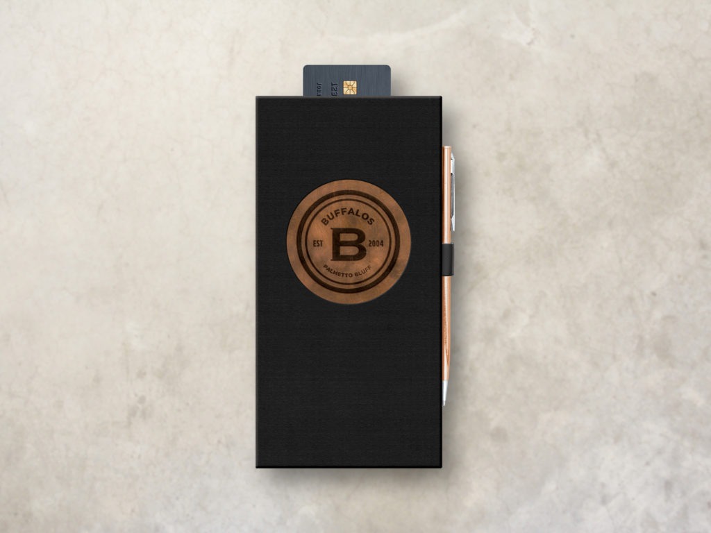 Black Check Presenter with pen loop and credit card pocket. The cover features a circular window with a copper underlay and printed black logo