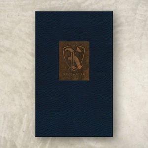 Blue ostrich leather menu cover with a copper inset and embossed logo