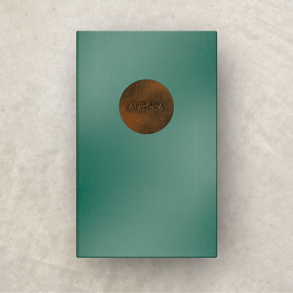A metallic teal menu cover with a circular weathered copper insert and embossed logo