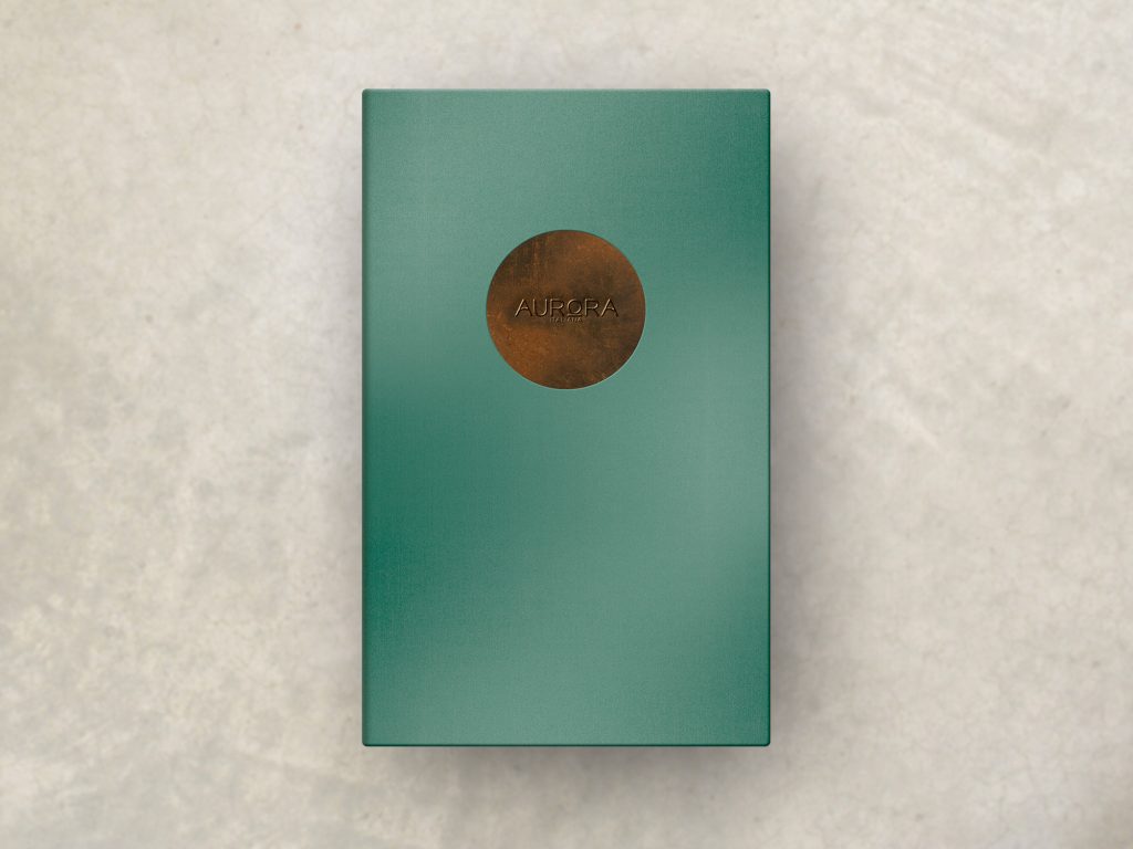 A metallic teal menu cover with a circular weathered copper insert and embossed logo